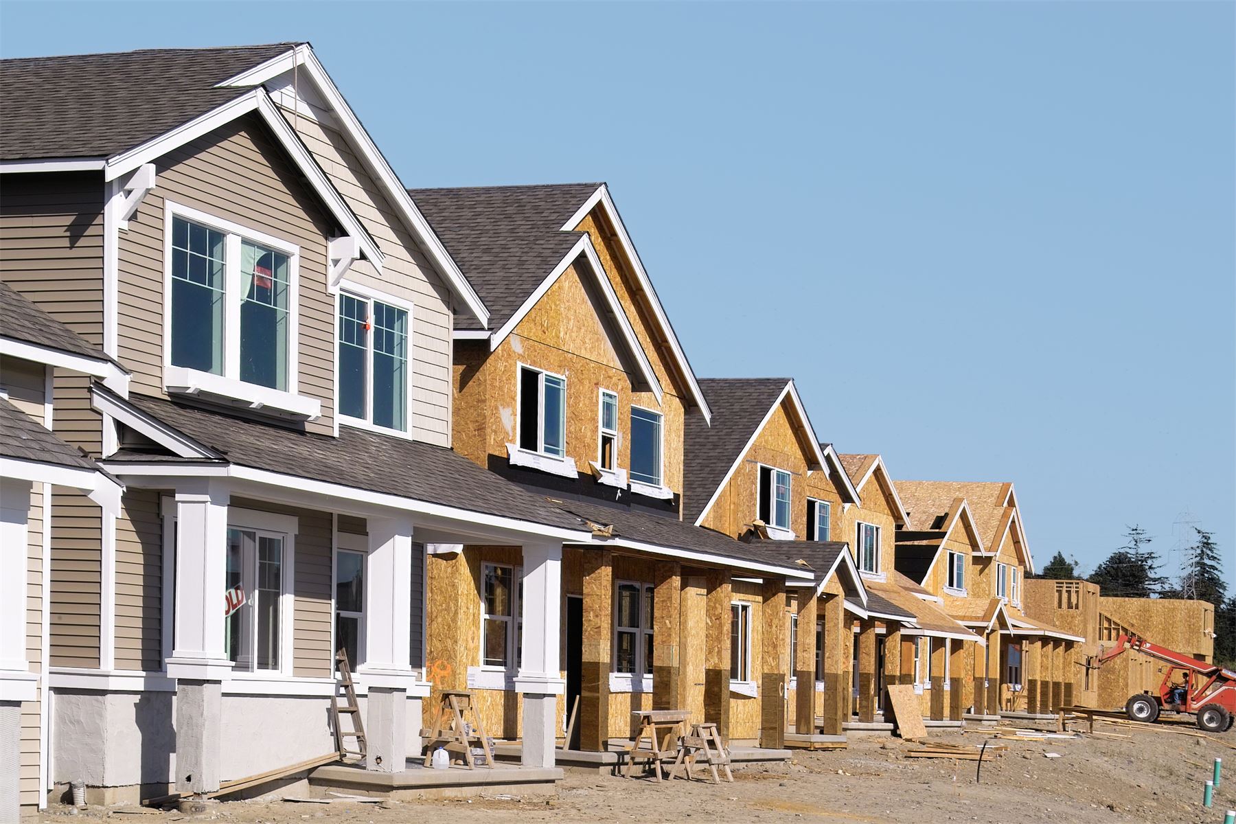 A row of newly built homes under construction in a housing development