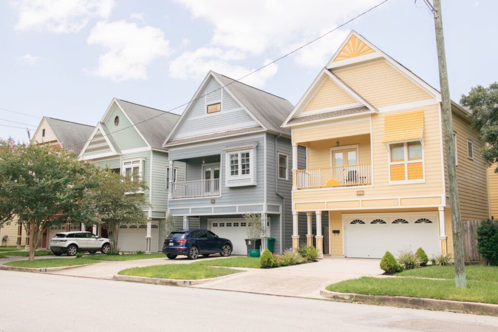 A row of two storey homes with painted siding, gutters and large windows